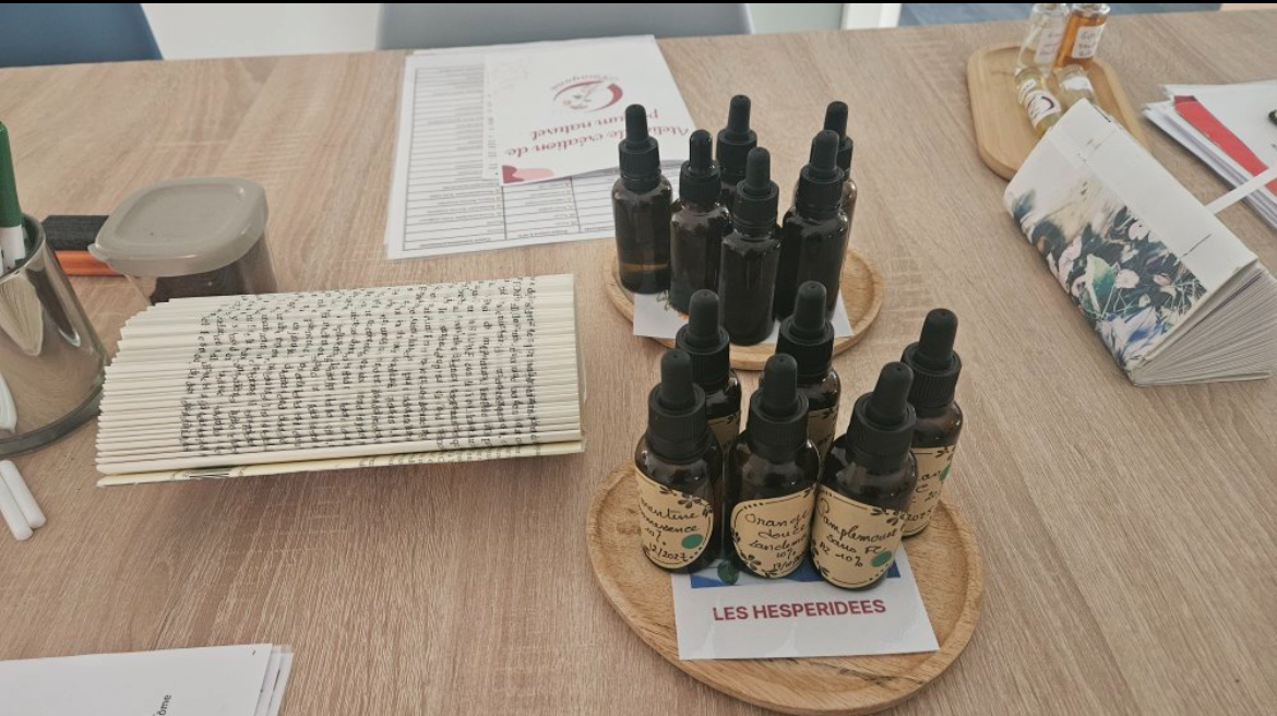 Gros plan sur les flacons d'huiles essentielles hespéridées de l'atelier